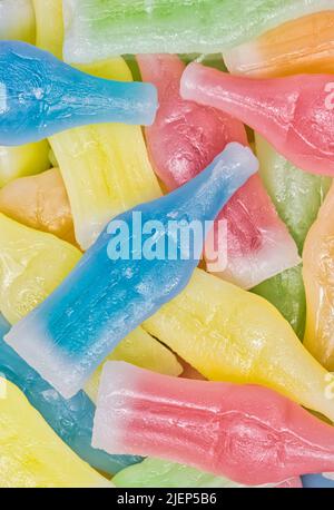 Wachsflaschen Süßigkeiten mit verschiedenen Farben und Geschmacksrichtungen verstreut. Direkt über flachem Lay-Makro. Stockfoto