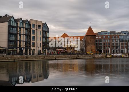 Danzig, Polen Mai 2022, moderne Gebäude über dem Motlawa-Fluss in der Altstadt. Tourismus auf dem Motlawa River. Neue Apartments-Architektur auf Granary Island Glasfenster mit Reflexionen. Touristisches Reiseziel Stockfoto