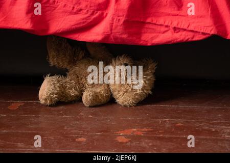 Ein Teddybär, ein Teddybär, liegt in der Nähe des Bettes auf dem Boden im Schlafzimmer zu Hause Stockfoto