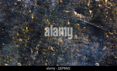 Luftdrohnen-Rundflug über schwarzer Aschefelde aus verbranntem braungelbem, trockenem Gras und weißem Rauch am sonnigen Herbsttag. Blick von oben. Textur natürlicher Hintergrund der ökologischen Umweltkatastrophe. Stockfoto