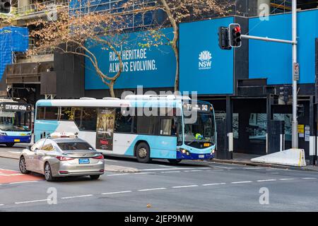 Australisches Taxi-Fahrzeug und öffentlicher Nahverkehr mit einem Einfachdeckerbus im Stadtzentrum von Sydney, NSW, Australien Stockfoto