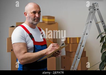 Mann mittleren Alters in Uniform Notizen auf Zwischenablage Stockfoto