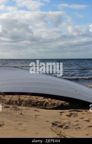 Fischerboot, das am Strand liegt. Der Ostseestrand und seine Landschaft an einem sonnigen Tag. Schiff an Land. Stockfoto