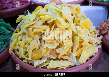 Schüssel mit getrockneten Mangofrüchten. Am Straßenmarktstand angezeigte Scheiben Stockfoto