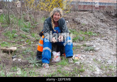 Sofia, Bulgarien. Porträt einer erwachsenen, kaukasischen Frau, die auf der straffen Bahnlinie sitzt und sich auf der Straße ausruht, bevor sie weiter in die Innenstadt spaziert. Stockfoto