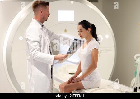 Der Arzt betrachtet die MRT-Untersuchung der Frau im Krankenhaus Stockfoto