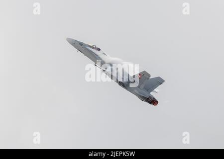 Die Schweizer Luftwaffe McDonnell Douglas FA-18C Hornet (REG: J-5026) spielt über der Ostküste über dem Meer. Stockfoto