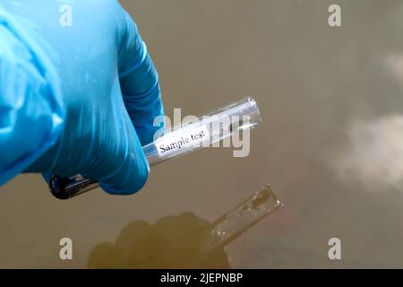 Sammeln Sie Proben von Abwässern aus industriellen Kanälen in Reagenzgläsern, die im Labor untersucht werden sollen Stockfoto