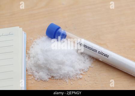 Ammoniumnitrat im Reagenzglas und Holzhintergrund Stockfoto
