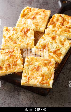 Alevropita Greek dünner Teig Feta Pie Nahaufnahme auf einem Holzbrett auf dem Tisch. Vertikal Stockfoto