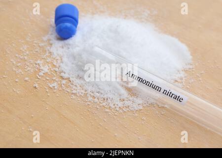 Ammoniumnitrat im Reagenzglas und Holzhintergrund Stockfoto