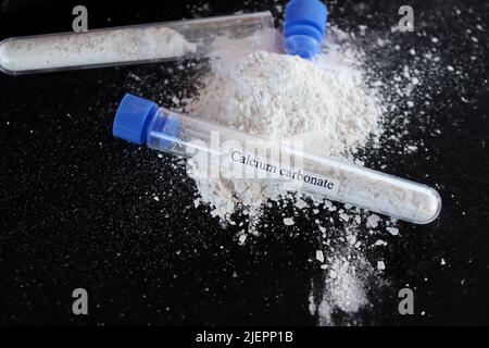 Calciumcarbonat im Reagenzglas und schwarzer Hintergrund Stockfoto