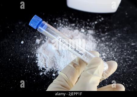 Calciumcarbonat im Reagenzglas und schwarzer Hintergrund Stockfoto