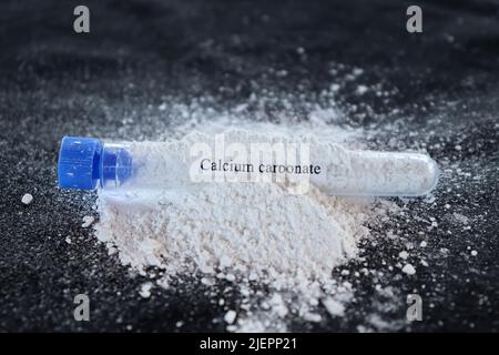 Calciumcarbonat im Reagenzglas und schwarzer Hintergrund Stockfoto