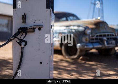 Eine Gaspumpe mit einem alten amerikanischen LKW im Hintergrund Stockfoto