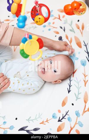 Babymassage. Mutter macht Gymnastik mit neugeborenem Kind Stockfoto