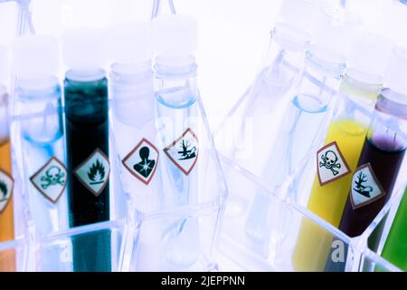 Chemikalien in Reagenzgläsern und Symbole, die im Labor oder in der Industrie verwendet werden Stockfoto