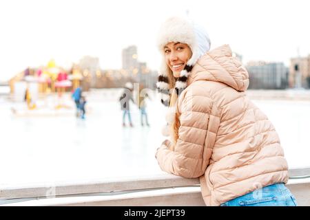 Winterporträt für Frauen. Schöne mittleren Alter kaukasischen weiblich stehend im Freien gekleidet lustig flauschigen Hut suchen Kamera Lächeln. Positive Weihnachten emotio Stockfoto