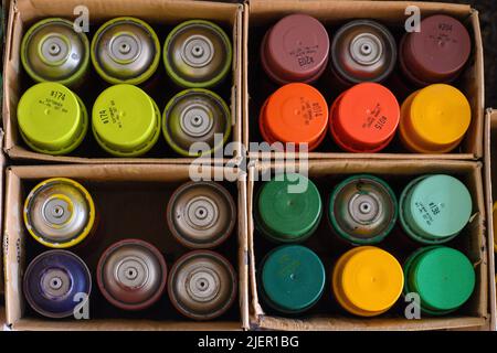 Magdeburg, Deutschland. 28.. Juni 2022. Farbdosen stehen in mehreren Kartons bereit. In einer Eisenbahnüberführung am Hauptbahnhof der Landeshauptstadt entsteht derzeit ein 250 Quadratmeter großes Graffito. Es ist eines von zwei Graffiti der Künstlerin Claudia Walde, das die Neubegrafiken in Zukunft schmücken wird. Die Arbeiten sollten bis Ende der Woche abgeschlossen sein. Aus rund 300 Dosen wird dann Farbe auf den Beton gesprüht. Quelle: Klaus-Dietmar Gabbert/dpa/ZB/dpa/Alamy Live News Stockfoto