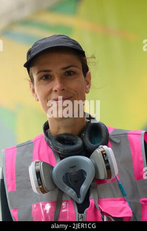 Magdeburg, Deutschland. 28.. Juni 2022. Die Künstlerin Claudia Walde steht in einer Bahnüberführung am Hauptbahnhof. Dort arbeitet sie derzeit an einem 250 Quadratmeter großen Graffito. Die Arbeiten sollten bis Ende der Woche abgeschlossen sein. Aus rund 300 Dosen wird dann Farbe auf den Beton gesprüht. Quelle: Klaus-Dietmar Gabbert/dpa/ZB/dpa/Alamy Live News Stockfoto