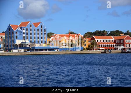 Pastellfarbene Kolonialgebäude an der Waterfront von Willemstad in der Nähe der Queen Emma Bridge, dem Kapitol von Curaçao, einer niederländischen Karibikinsel. Stockfoto