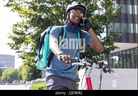 Kurier Auf Dem Fahrrad Liefert Takeaway Food In Der Stadt Telefonieren Auf Dem Handy Stockfoto