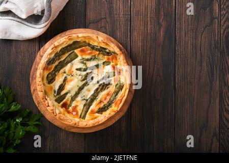 Quiche. Hausgemachter Spargelkuchen oder Quiche mit Käse und Spinat auf altem dunklen Holztisch Hintergrund. Draufsicht. Stockfoto