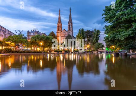 Die Evangelische Stadtkirche und der Brunnen auf dem Augustaplatz in der Abenddämmerung, Baden-Baden, Baden-Württemberg, Deutschland | der Protestant Stockfoto