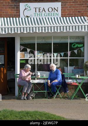 Zwei ältere Damen, die vor dem traditionellen Teeladen clare suffolk england Tee trinken Stockfoto