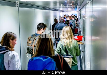 Schiphol, Niederlande. 26.. Juni 2022. Eine lange Schlange von Reisenden wird gesehen, wie sie auf dem Weg zum Flughafen Schiphol durch eine Jetbrücke gehen. Der Flughafen warnt nun unmissverständlich davor, dass es in den kommenden Wochen stundenlange Warteschlangen geben könnte. In der kommenden Zeit wird es ungefähr so voll sein wie während der Maifeiertage. KLM bremst den Verkauf von Tickets für Flüge ab Schiphol in den kommenden Tagen. (Foto von Robin Utrecht/SOPA Images/Sipa USA) Quelle: SIPA USA/Alamy Live News Stockfoto