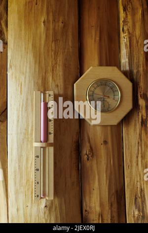 Saunathermometer und Hygrometer, Sanduhr auf Holzwand Stockfoto