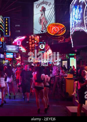 Touristen spazieren durch das Soi Cowboy, eines der berühmten Rotlichtviertel Bangkoks. Stockfoto