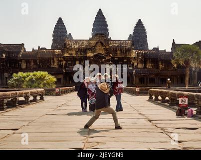 Der Fotograf fotografiert eine Gruppe von Touristen vor dem Tempel Angkor Wat. Stockfoto