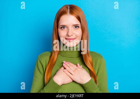 Portrait von attraktiven fröhlichen Mädchen berührt Herz aufrichtig isoliert über hellen blauen Hintergrund Stockfoto