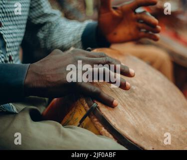 Nahaufnahme eines Mannes, der während eines Festivals eine afrikanische Trommel spielt Stockfoto