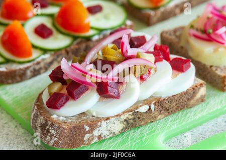 Eingelegte rote Zwiebel, Gurken, Rote Beete und Ei-Sandwich im dänischen Stil. Stockfoto