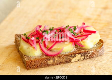 Dänisches Sandwich mit eingelegten roten Zwiebeln und offenen Kartoffeln Stockfoto