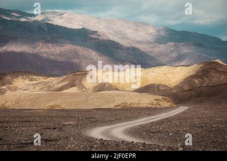 Eine Nebenstraße führt in die Wüste im Death Valley National Park, Kalifornien. Stockfoto