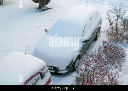 Autos parkten auf einer von oben in Schnee gehüllten Auffahrt, Fife, Schottland. Stockfoto