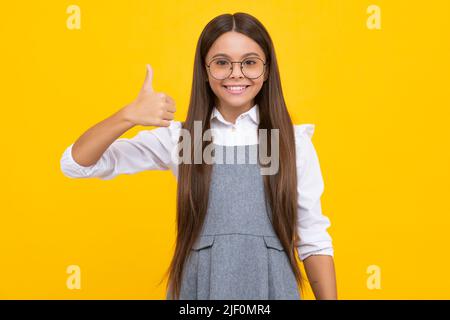 Glücklich lustige Teenager Kind Mädchen zeigen Anblick Daumen nach oben und Viel Glück. Glückliches Mädchengesicht, positive und lächelnde Emotionen. Stockfoto