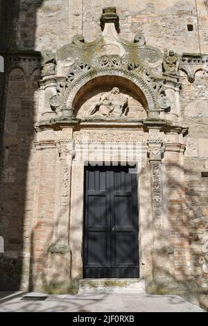 Die Eingangstür zu einer mittelalterlichen Kirche in Miglionico, einer historischen Stadt in der Provinz Matera in Italien. Stockfoto