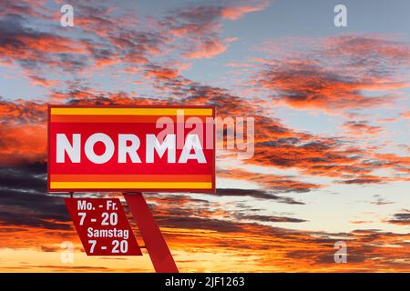 AUGSBURG, DEUTSCHLAND – 16. JUNI 2022: Werbeschild des Discounter-Stores NORMA vor einem wolkenbewölkten Himmel Stockfoto