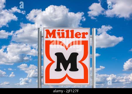 AUGSBURG, DEUTSCHLAND – 16. JUNI 2022: Werbeschild der Drogerie Müller vor einem wolkenbewölkten Himmel Stockfoto
