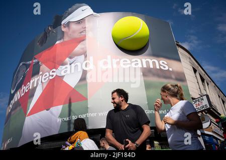 Die britische Tennisspielerin Emma Raducanu erscheint am ersten Wettkampftag während der Wimbledon Lawn Tennis Association Championships am 27.. Juni 2022 in London, England, auf einer riesigen Plakatwand im Stadtzentrum von Wimbledon. Stockfoto