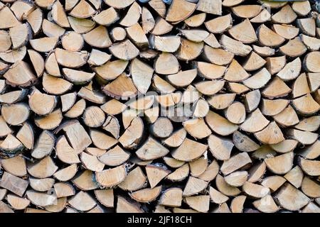 Holzstapel. Wand aus gehacktem Holz, Hintergrund aus trockenem gehacktem Holz im Stapel gestapelt Stockfoto