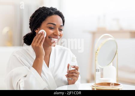 Happy Black Lady Mit Micellar Water Und Cotton Pad Für Die Hautreinigung Stockfoto