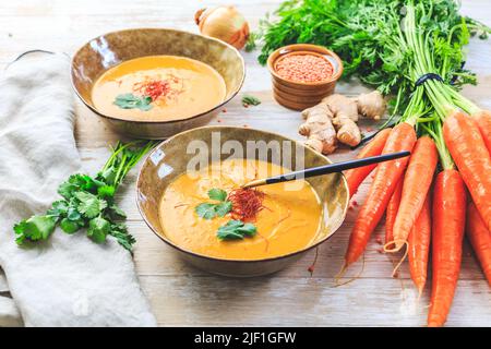 Hausgemachte rote Linsensuppe mit Karotten, Ingwer und Kokosmilch mit Zutaten Stockfoto