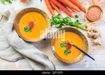 Hausgemachte rote Linsensuppe mit Karotten, Ingwer und Kokosmilch mit Zutaten Stockfoto