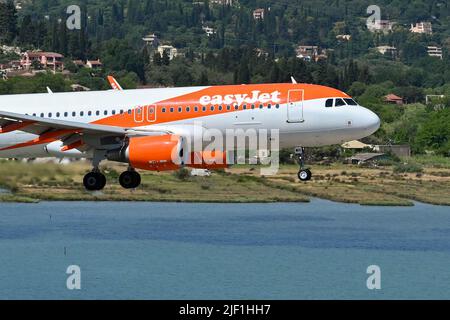 Korfu, Griechenland - Juni 2022: Der easyJet Airbus A320 (Registrierung G-EZWH) fliegt auf dem Landeanflug auf dem Flughafen von Korfu tief über Wasser. Stockfoto