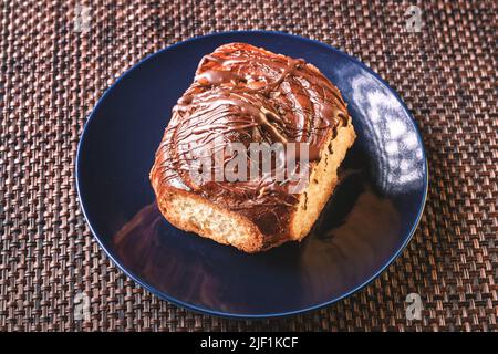 Köstlicher hausgemachter Biskuitkuchen mit Schokolade auf einem weißen Teller, ideal zum Nachtisch Stockfoto